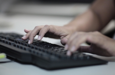 mãos digitando num teclado de computador